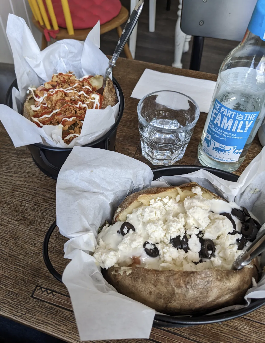 Gefüllte Ofenkartoffel mit Feta und schwarzen Oliven in einem Körbchen